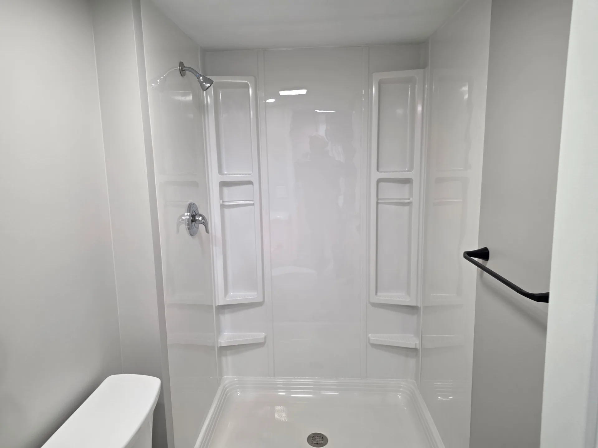Clean white shower stall with built-in shelving