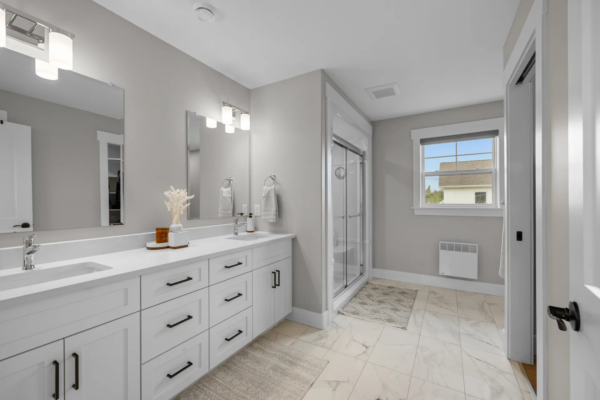 Primary bathroom with white vanity, quartz countertop, and glass-enclosed shower