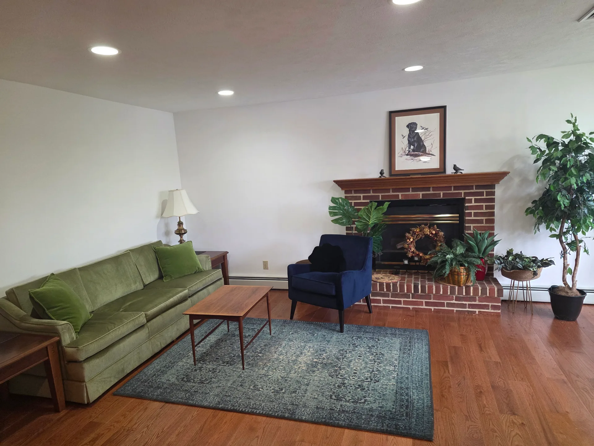 Living room seating area with brick fireplace hearth and hardwood floors