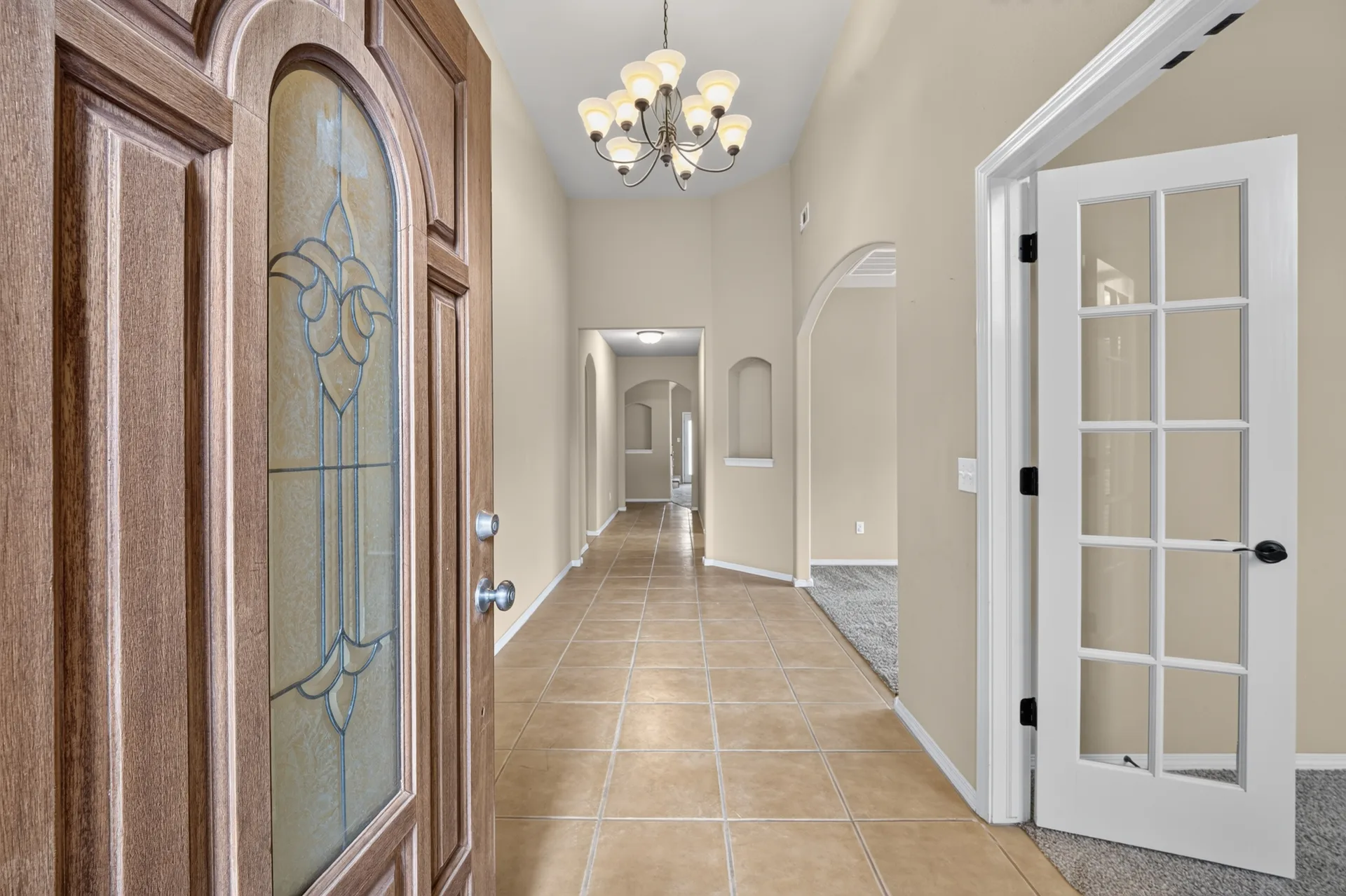 Looking in from the front door at the foyer of 4604 N Narcissus Ave, with tile floors, archways, and high ceilings