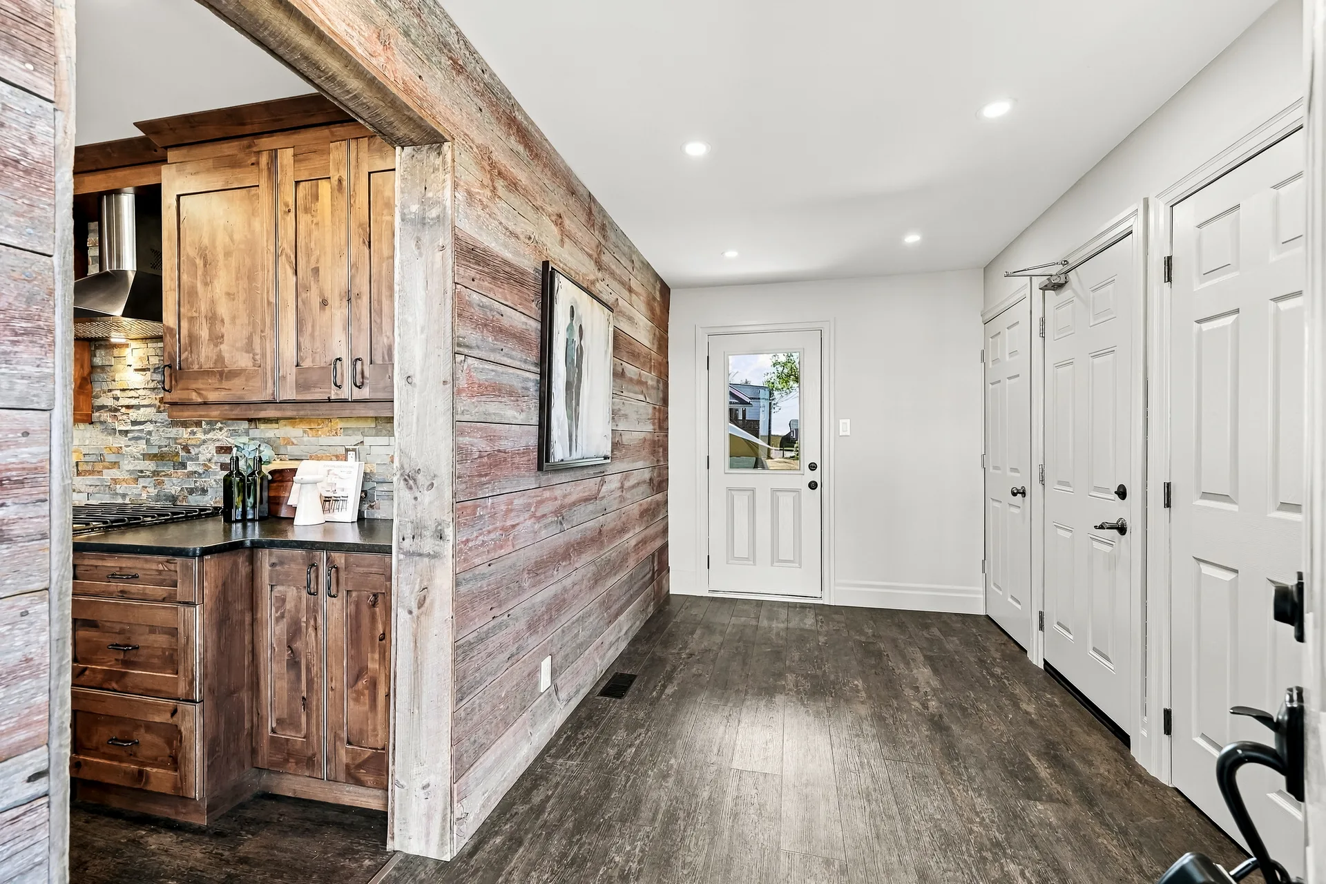 Interior hallway with wood-plank cladding leading past the kitchen