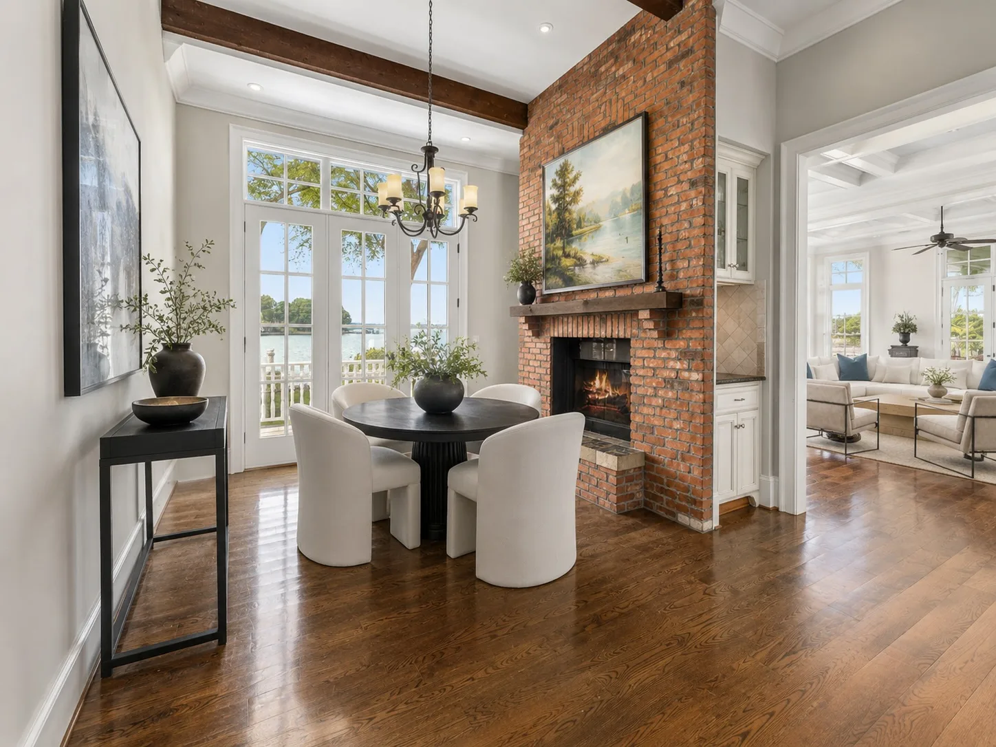 Eat-in kitchen area with exposed brick fireplace, timber mantle, and French doors