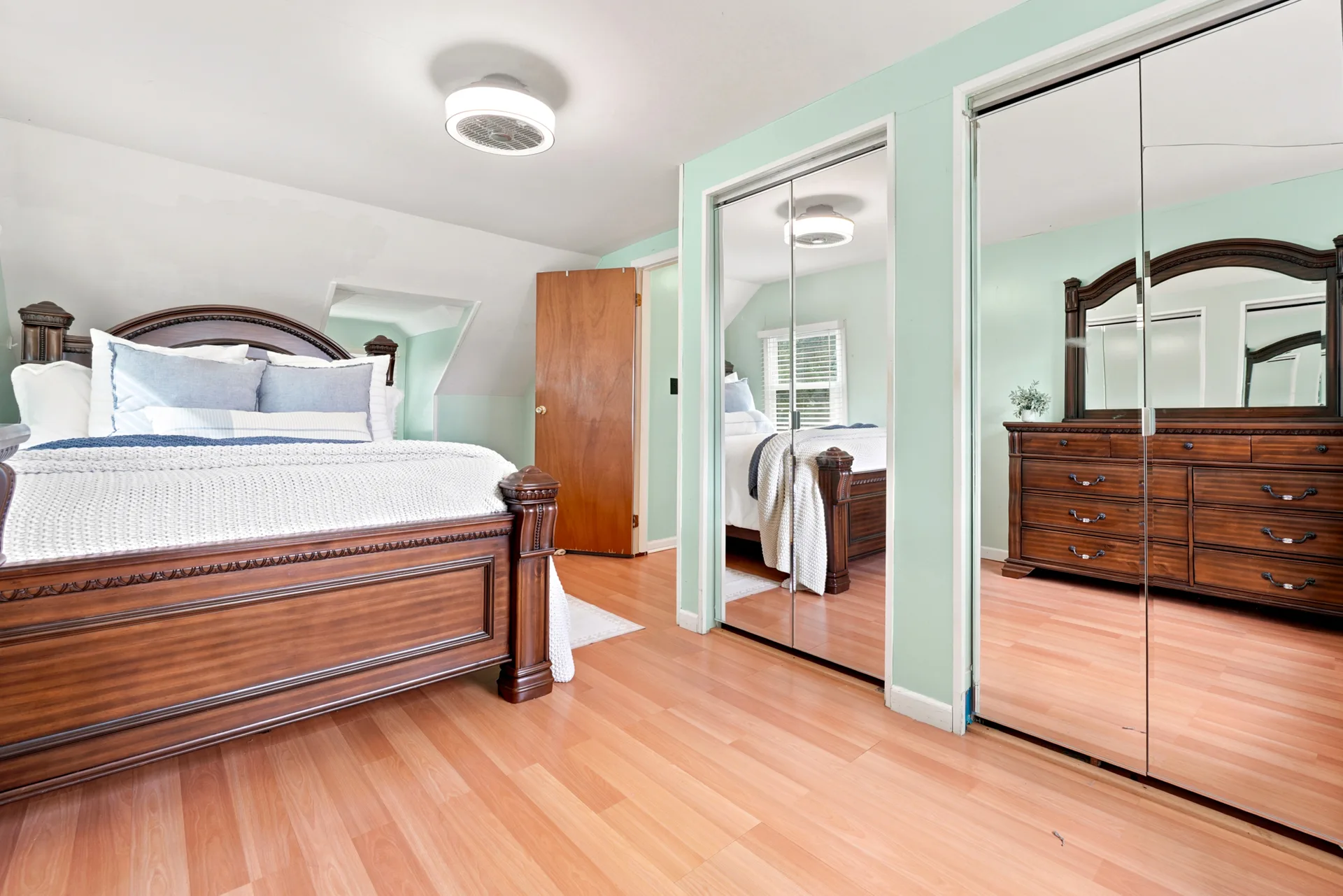 Primary bedroom with large floor-to-ceiling mirrored closet doors