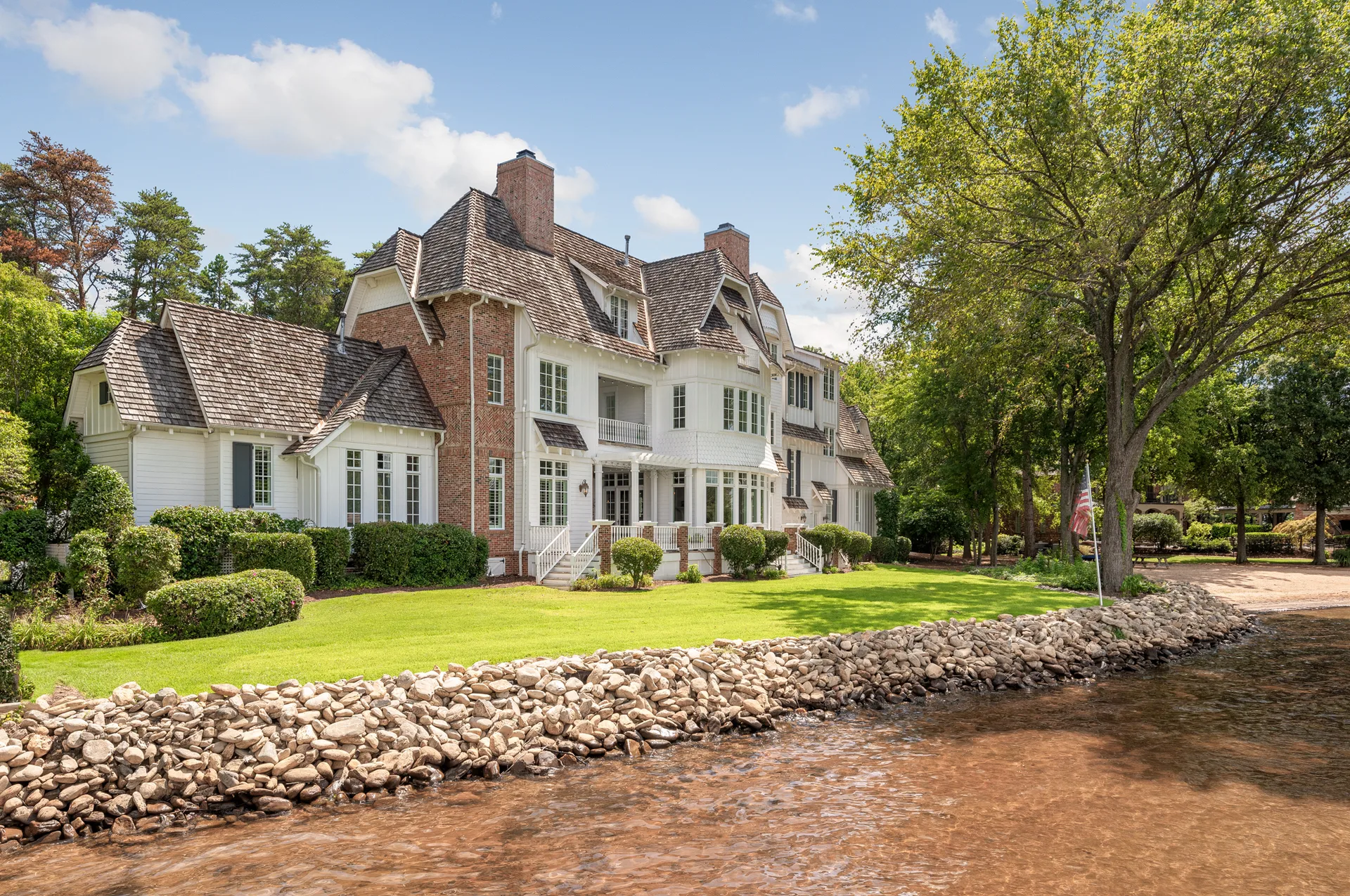 Waterfront facade with green lawn and rock retaining wall