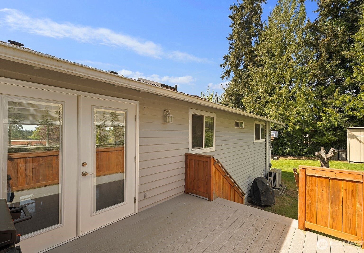 Back deck with French doors opening to tree-lined backyard