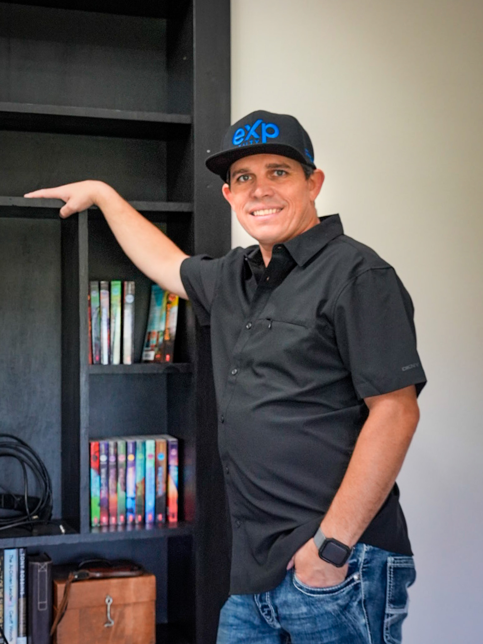 Travis Wright, REALTOR with eXp Realty, wearing a black cap and button-down shirt