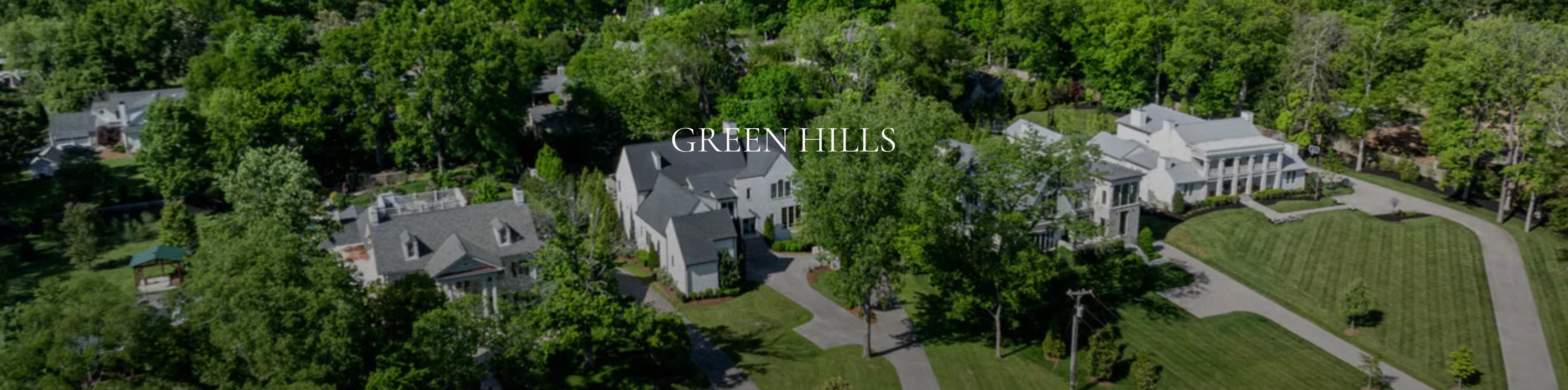 Aerial panoramic view of luxury estate homes nestled in lush green trees in Green Hills