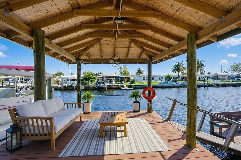 Covered boat dock with outdoor seating overlooking the canal