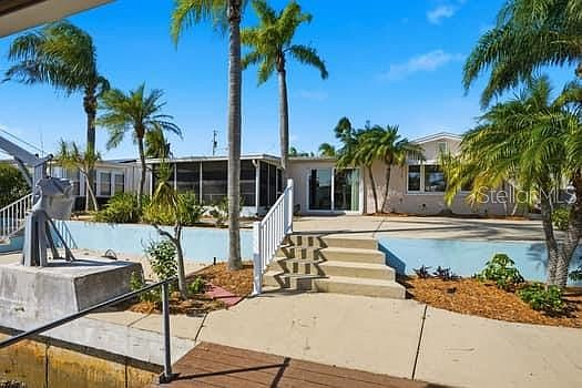 Two-level concrete backyard with white railings and canal access