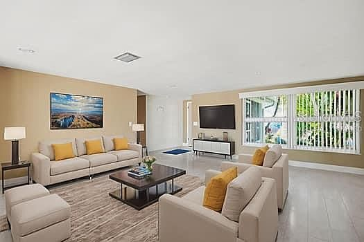 Living room with sofa, television, and bright daylight from the window