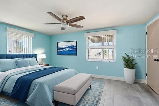 Second bedroom with blue upholstered bed and ocean wall art