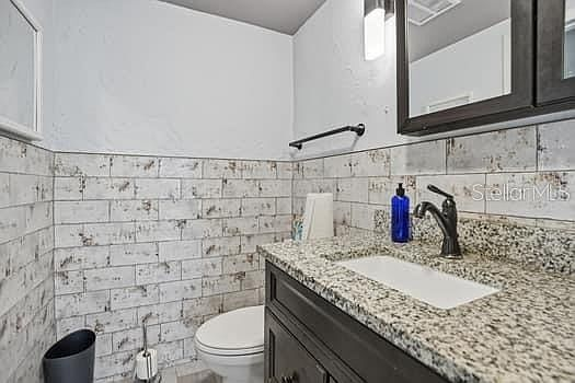 Bathroom with granite vanity and dark wood cabinet