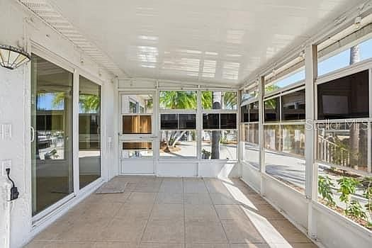Screened-in Florida room with tile flooring and sliding glass doors
