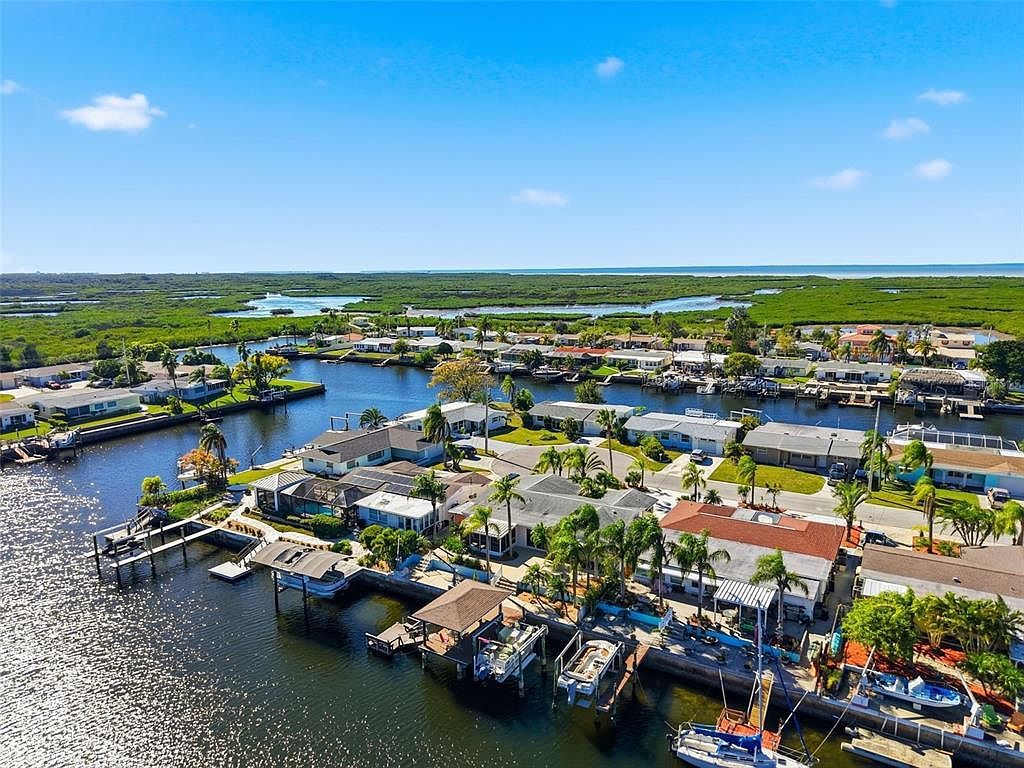 Aerial panorama of the Leisure Beach canal community with Gulf waters visible in the background