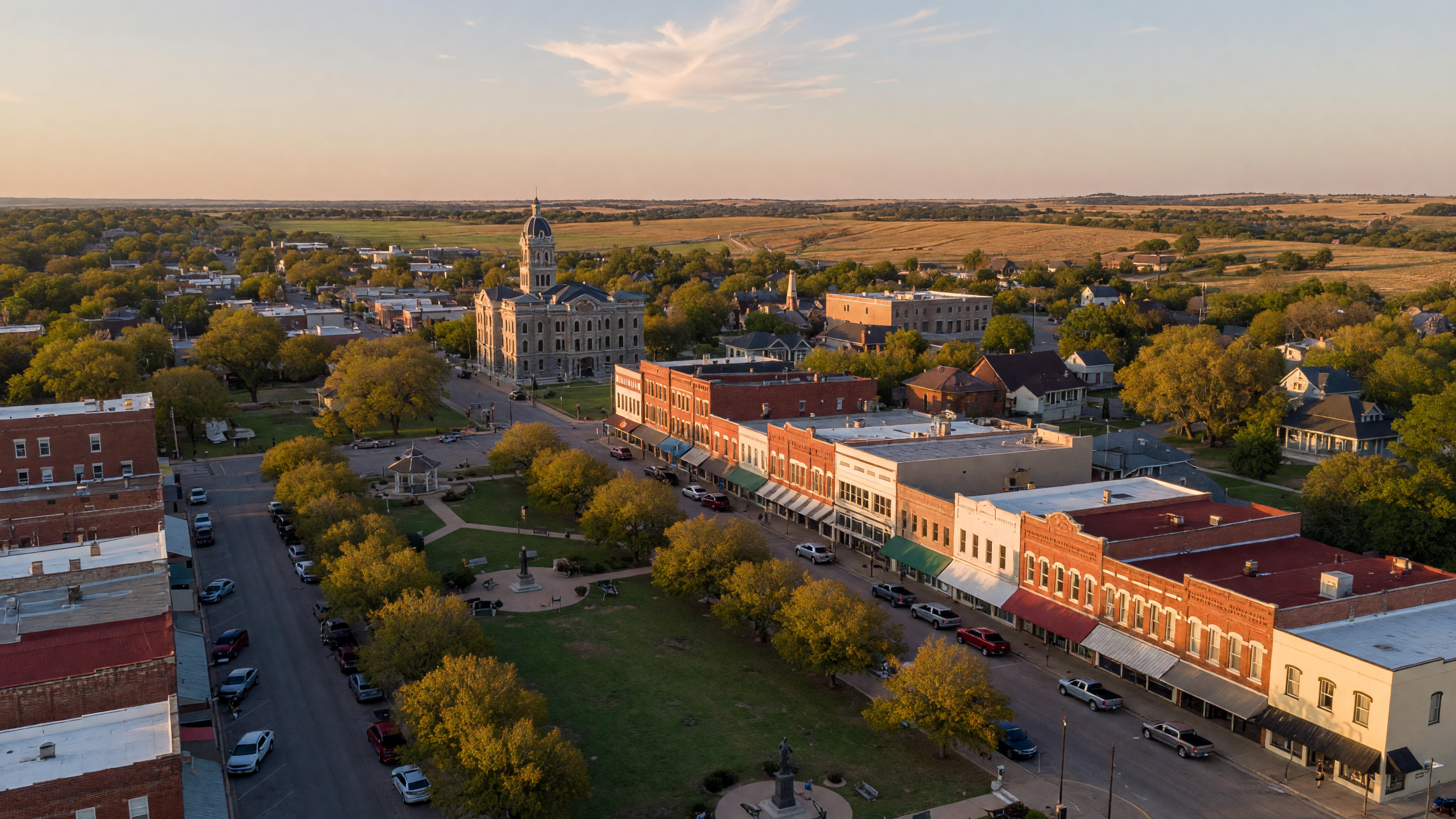 A warm sunlit view of downtown Sherman, Texas with historic brick buildings and tree-lined streets