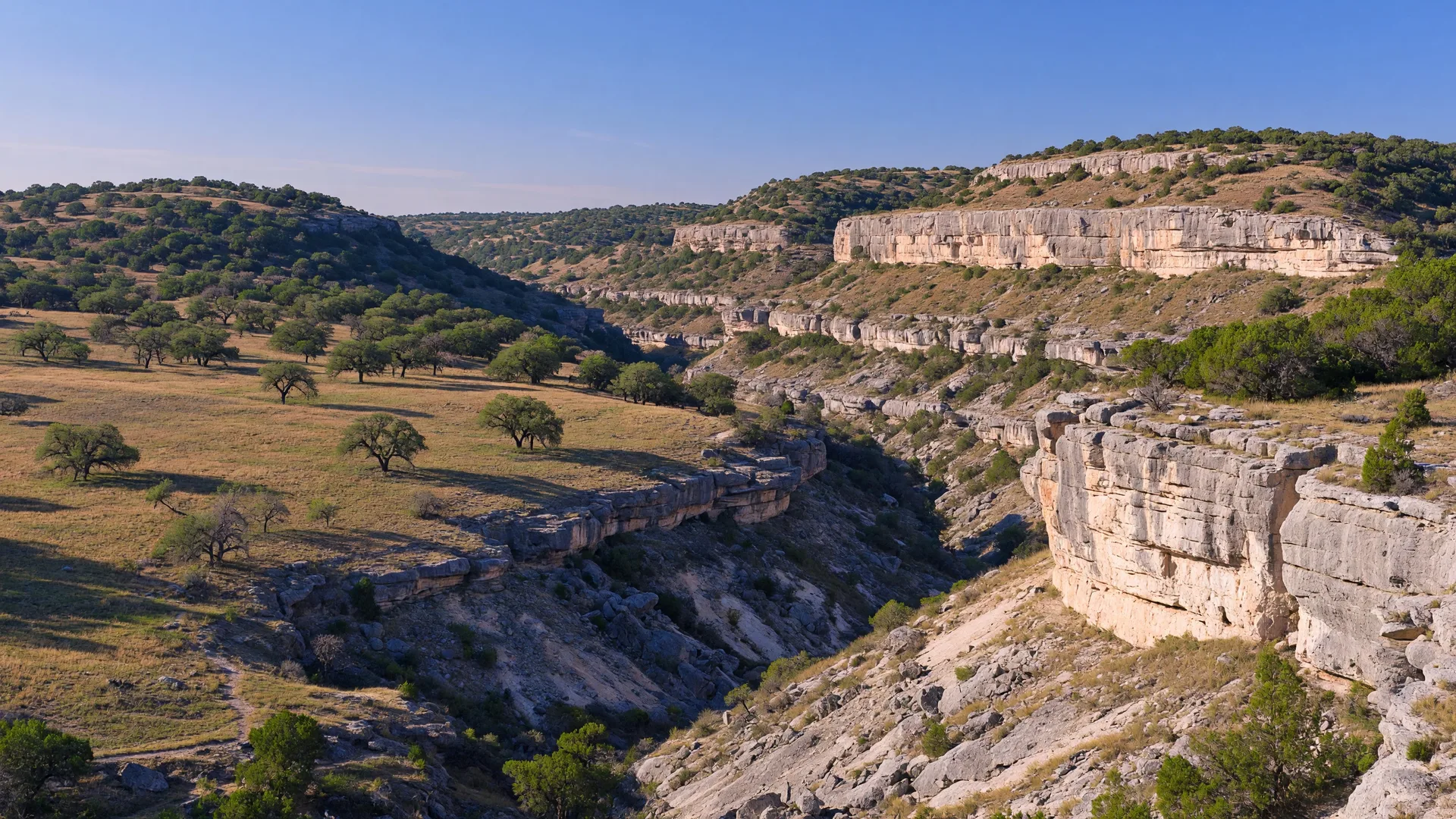 Rugged limestone canyon terrain with exposed rocky outcrops and rolling Hill Country grasslands at Government Canyon State Natural Area