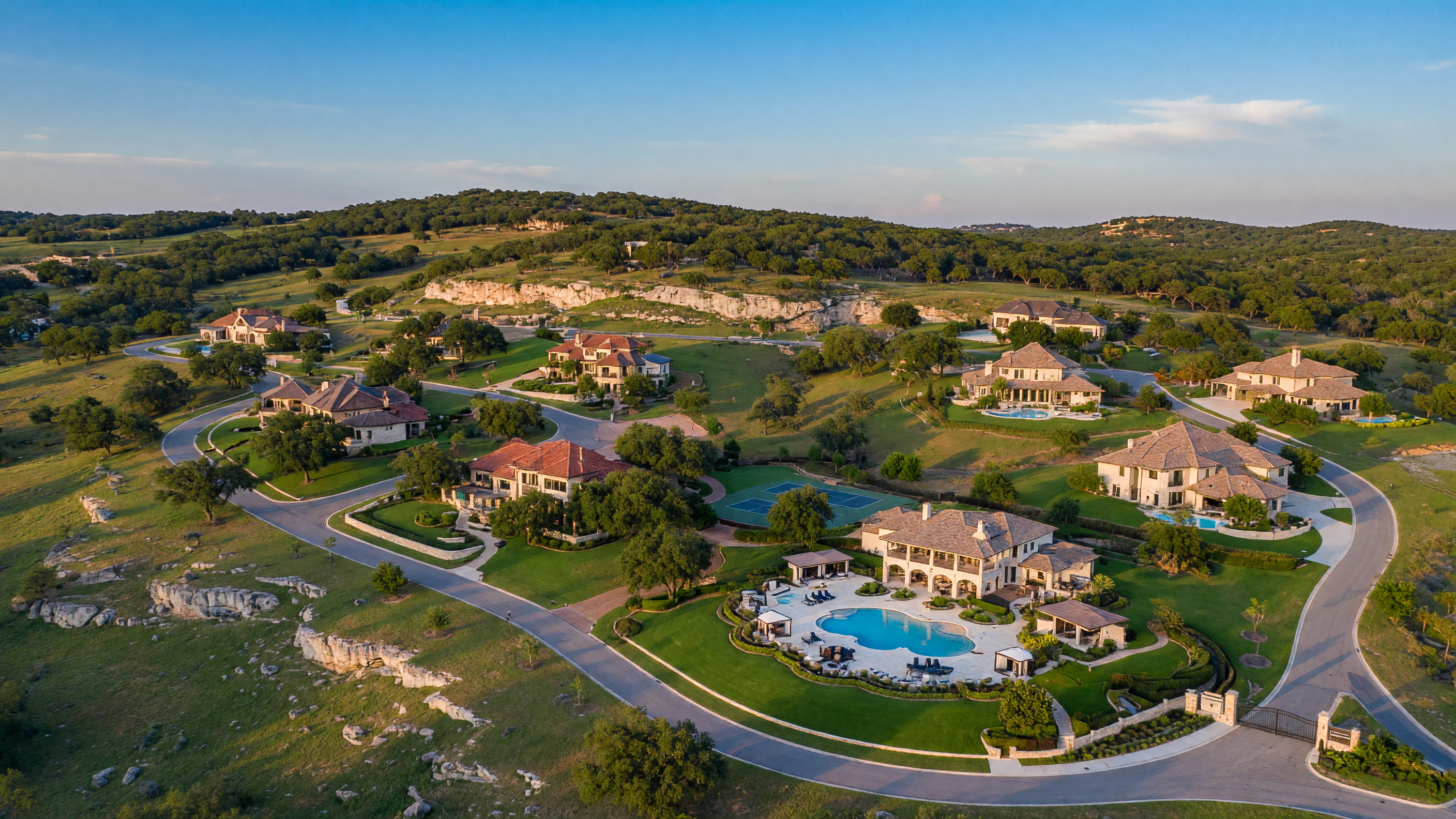Resort-style community amenity center with lazy river pool, clubhouse pavilion, and Hill Country landscaping in Fair Oaks Ranch