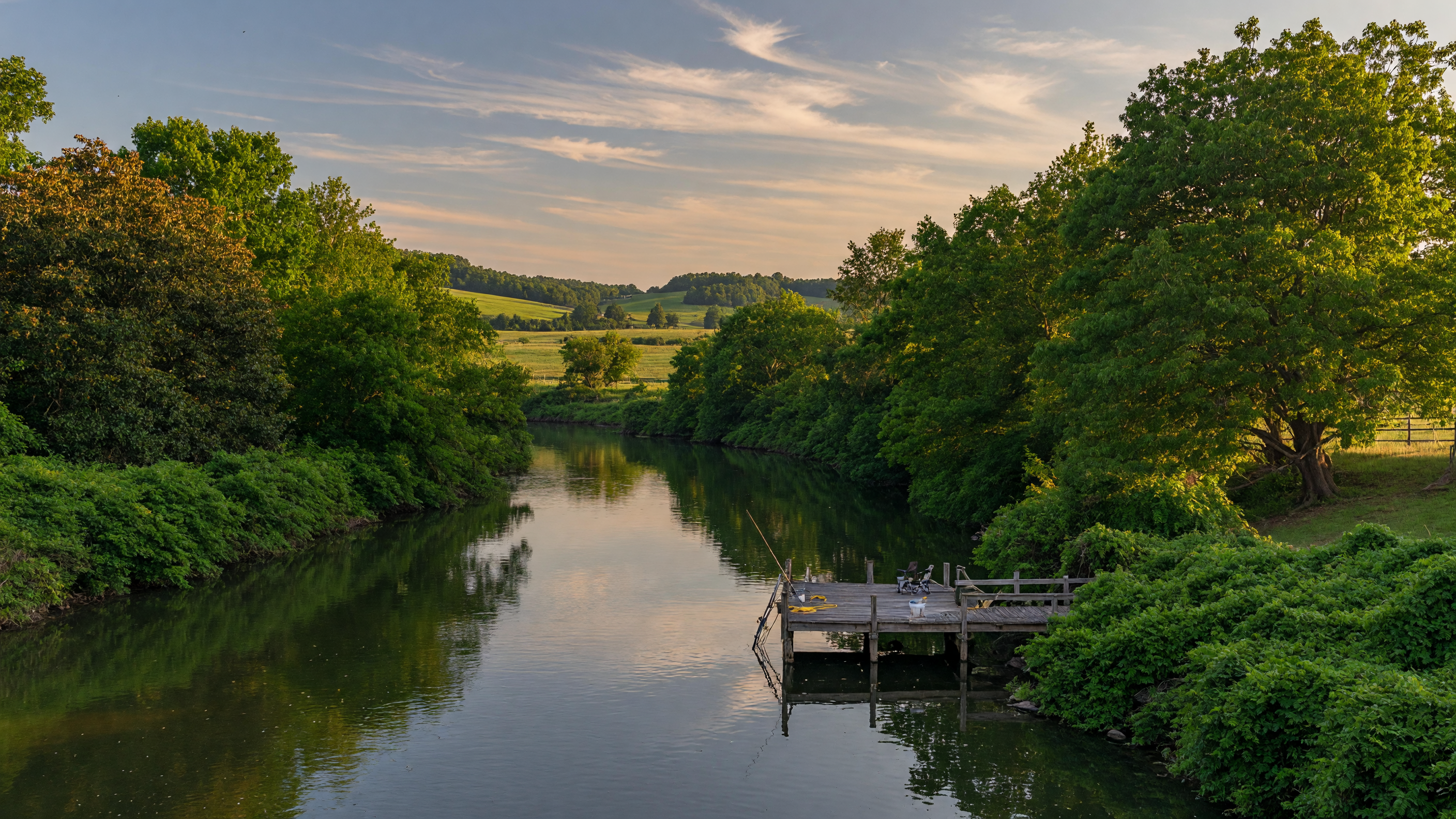 The Appomattox River flowing through a lush Virginia summer landscape near Petersburg with calm water and green tree canopy
