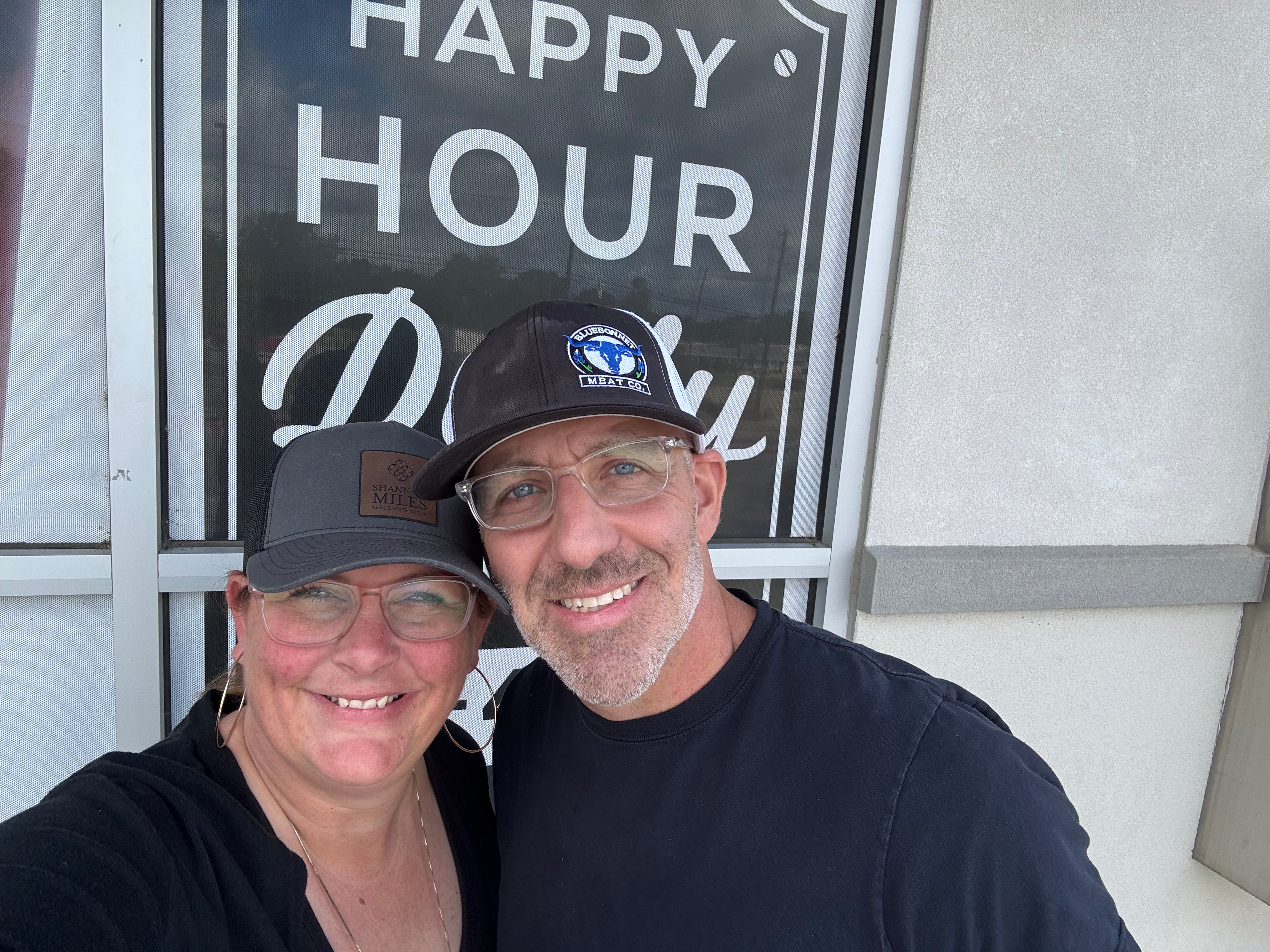 Shannon Miles selfie with partner in front of a sign