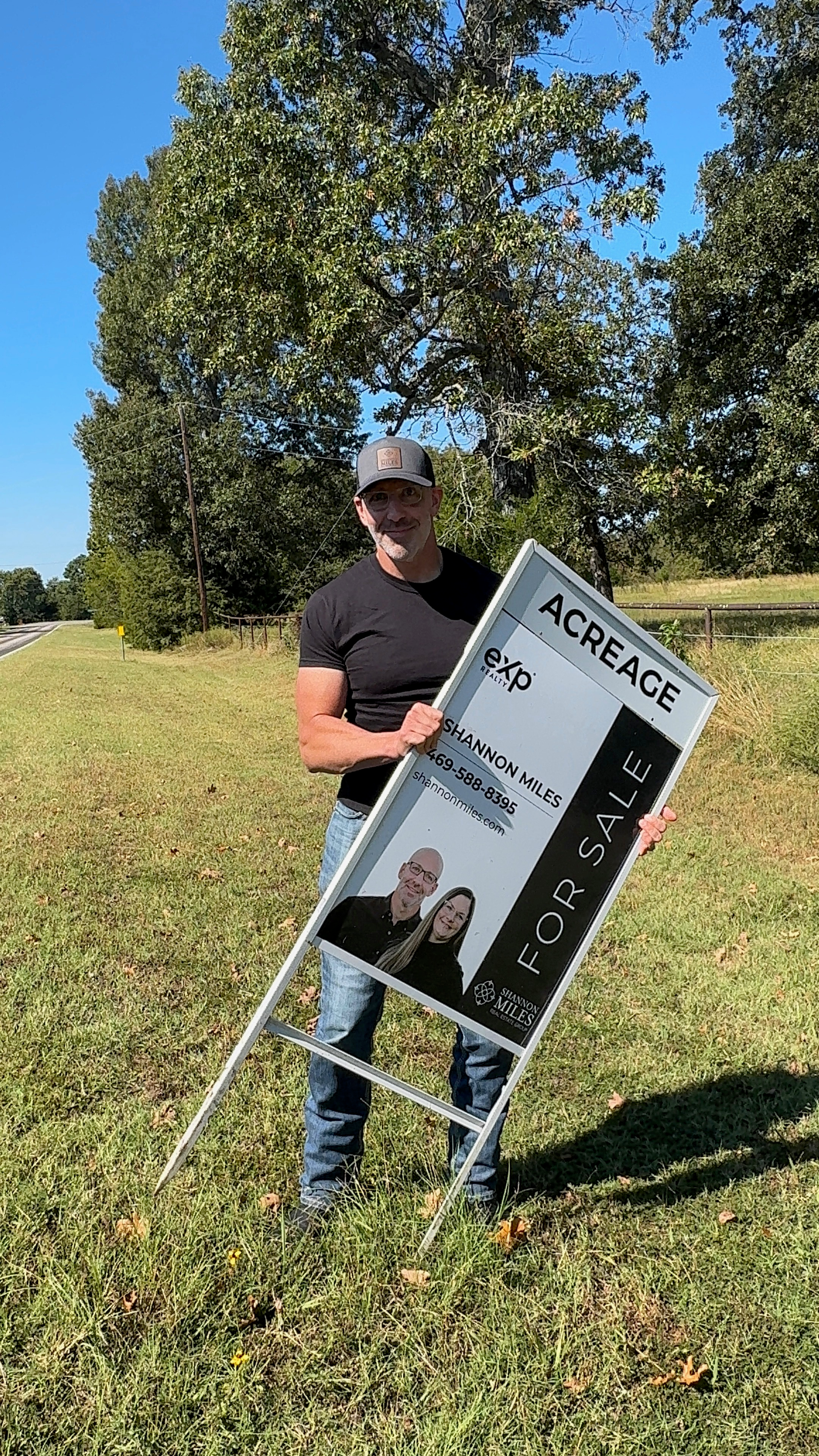Scott with eXp Realty acreage sign in a grassy field