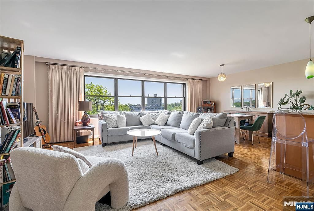 Open-concept living room with parquet floors and oversized picture windows