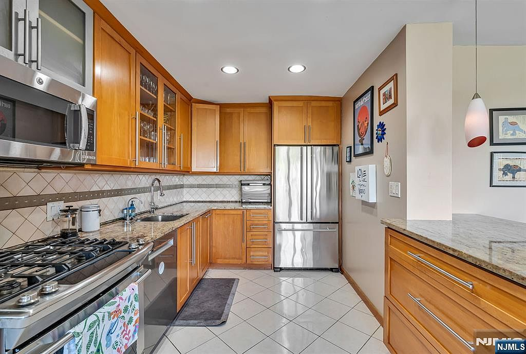 Renovated kitchen with wood shaker cabinetry and granite counters