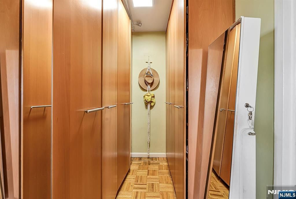 Primary bedroom walk-in closet with custom floor-to-ceiling wood cabinetry