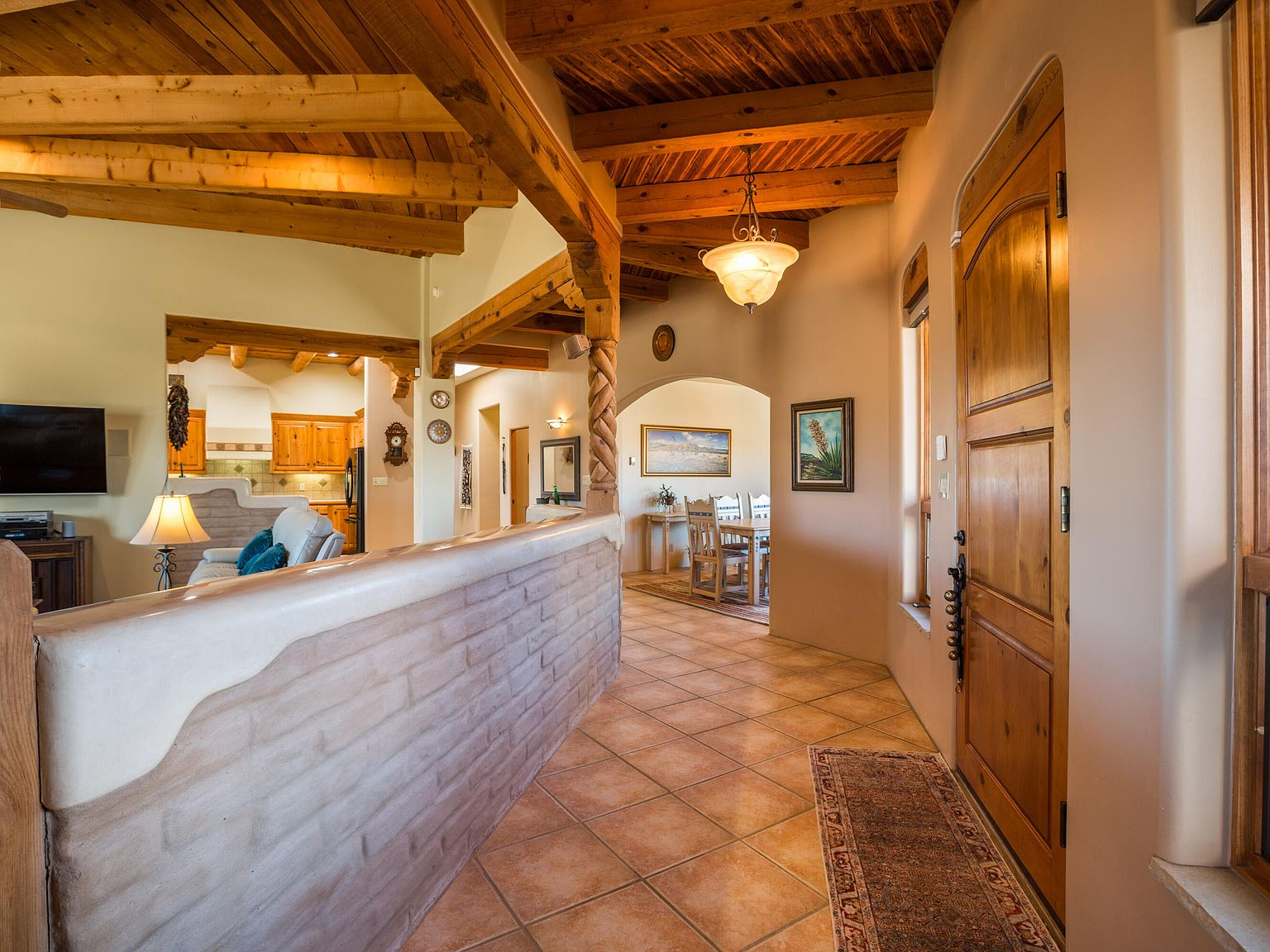 Southwestern-style entryway with exposed adobe brick and viga ceiling beams