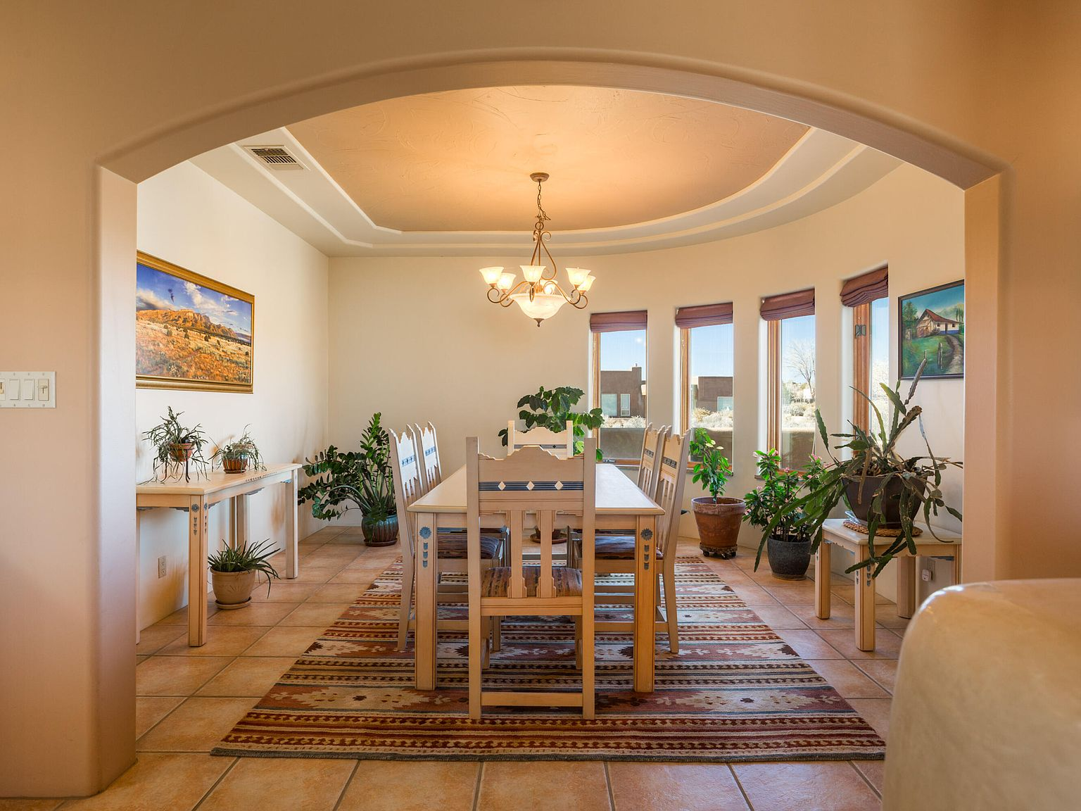 Dining room with curved window wall and terracotta tile floors
