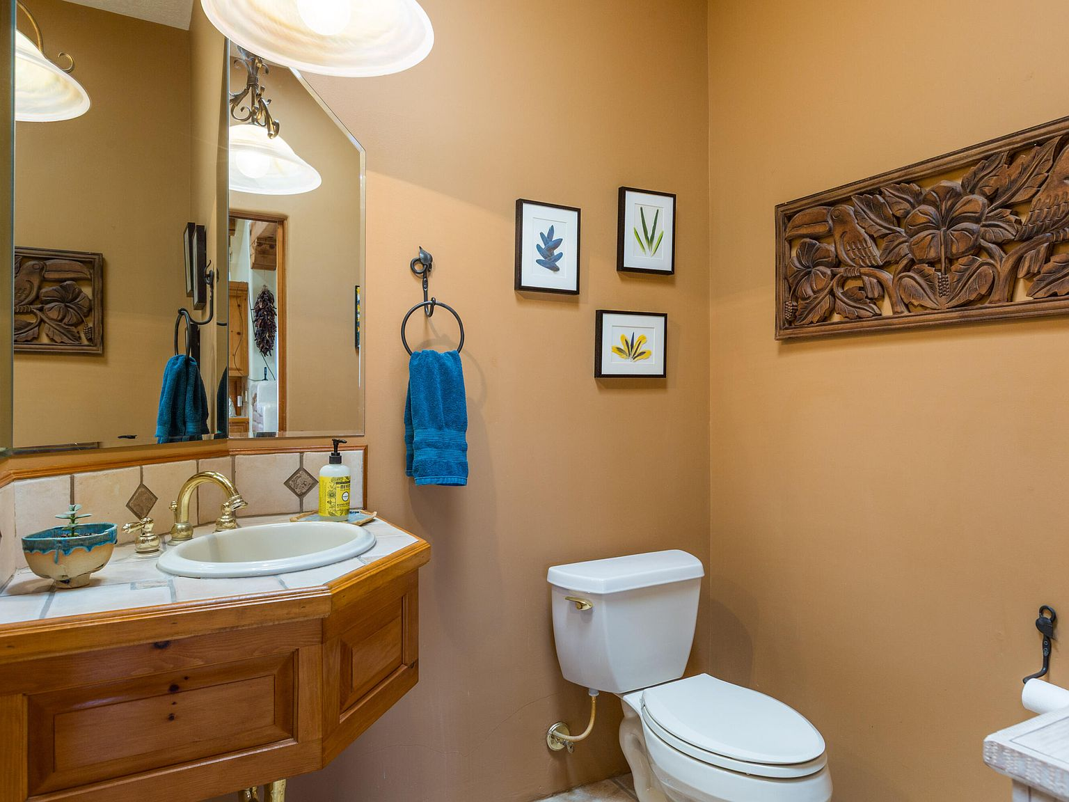 Powder room with terracotta plaster walls and tiled vanity