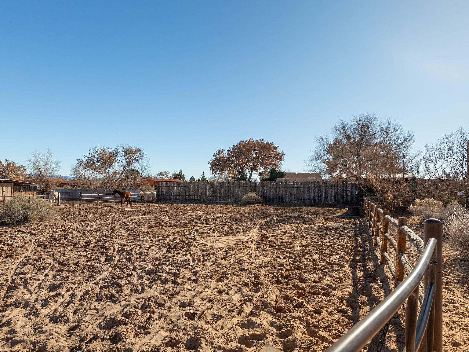 Horse corral and paddock with coyote fencing on the property