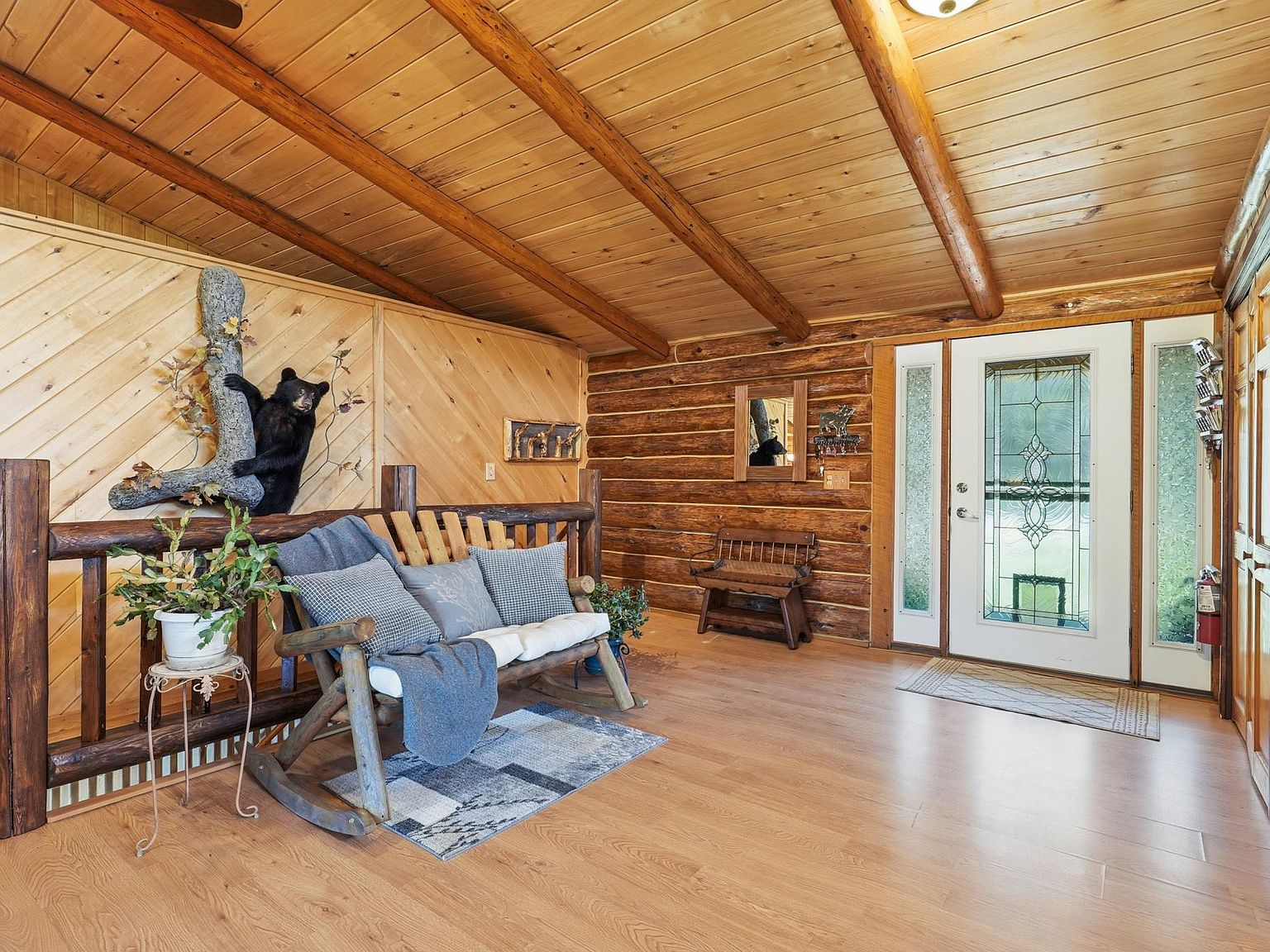 Rustic log entryway with wood plank ceiling and pine walls
