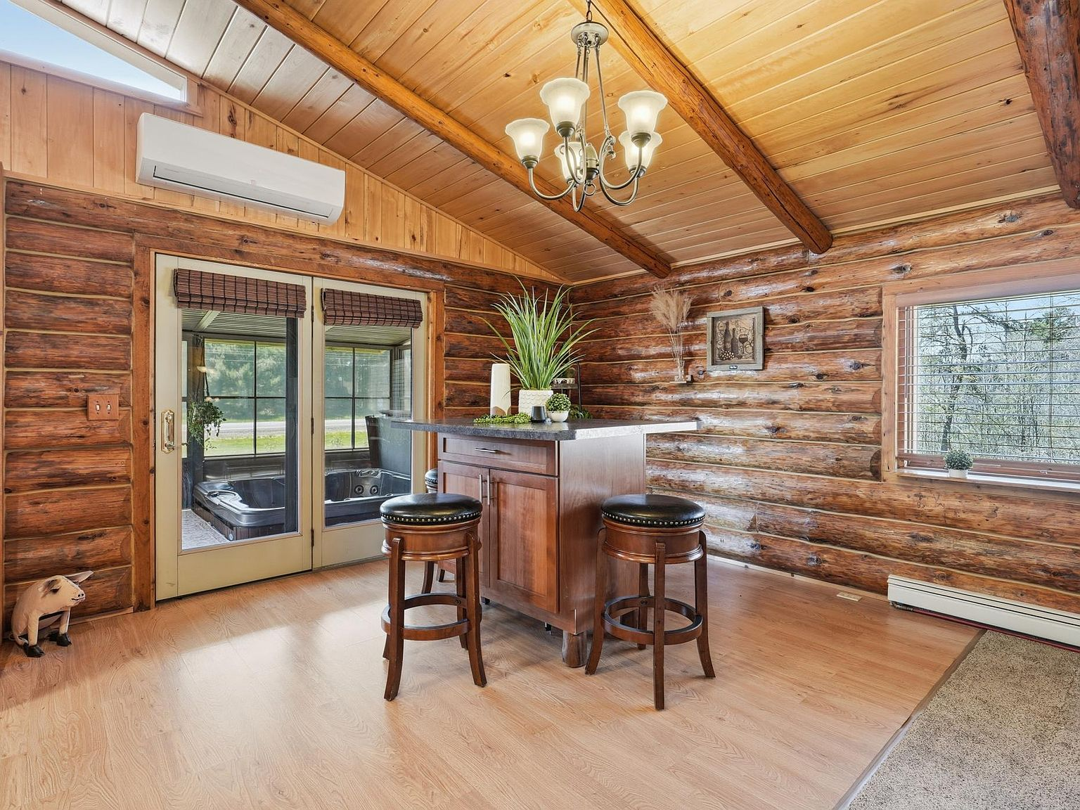 Dining area with exposed log walls and vaulted wood ceiling