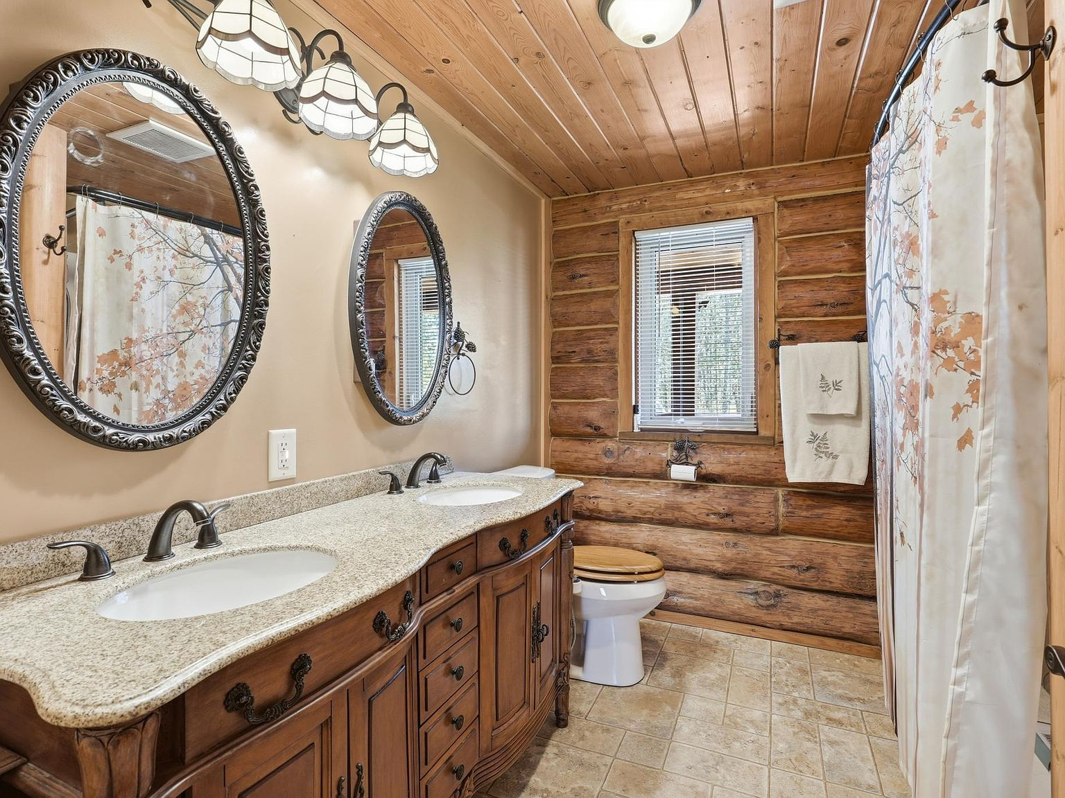 Bathroom with log walls and granite vanity