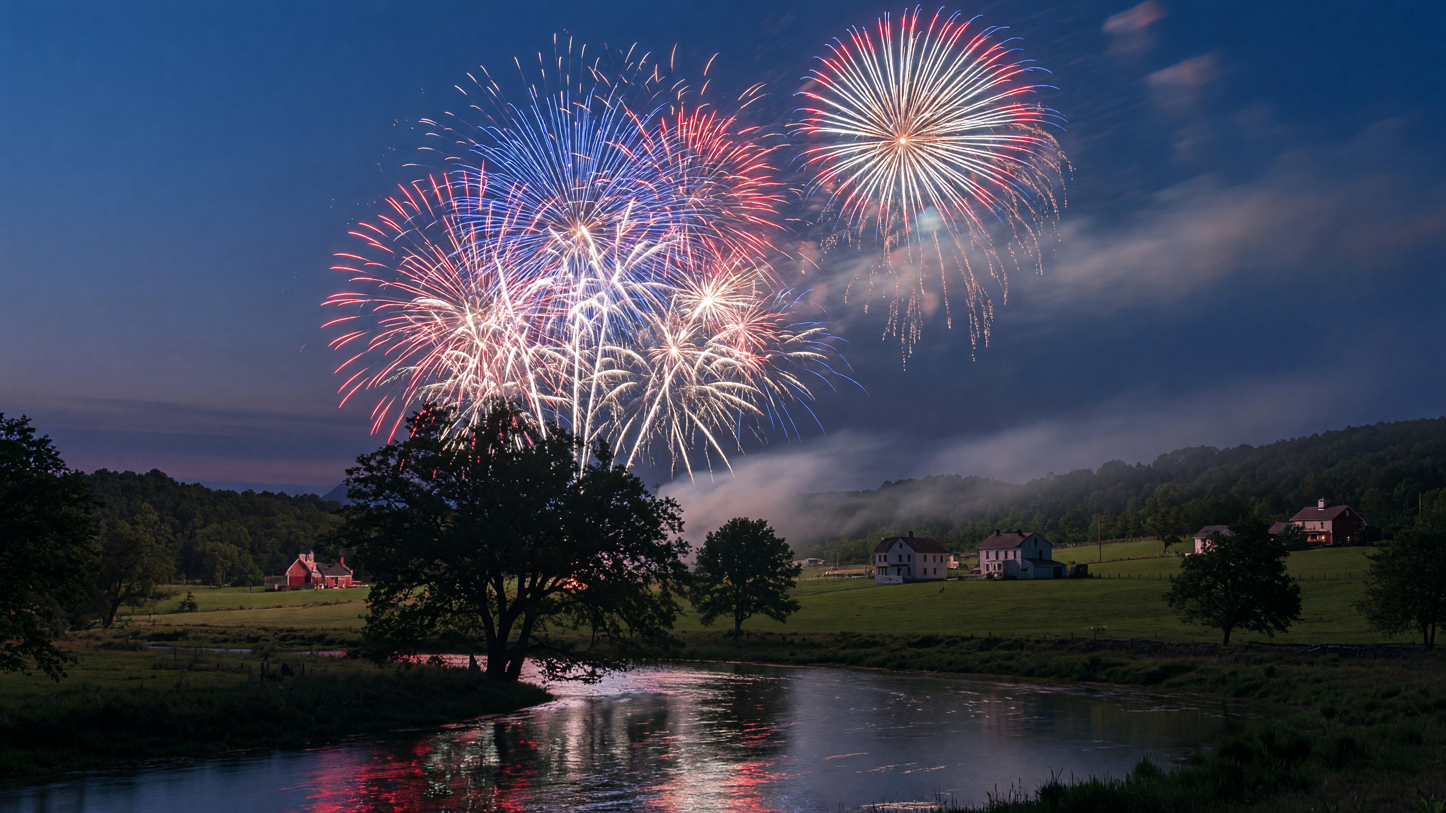 Spectacular 4th of July fireworks display illuminating the night sky over a peaceful Virginia river, with red, white, and blue bursts reflecting on calm water and tree-lined banks