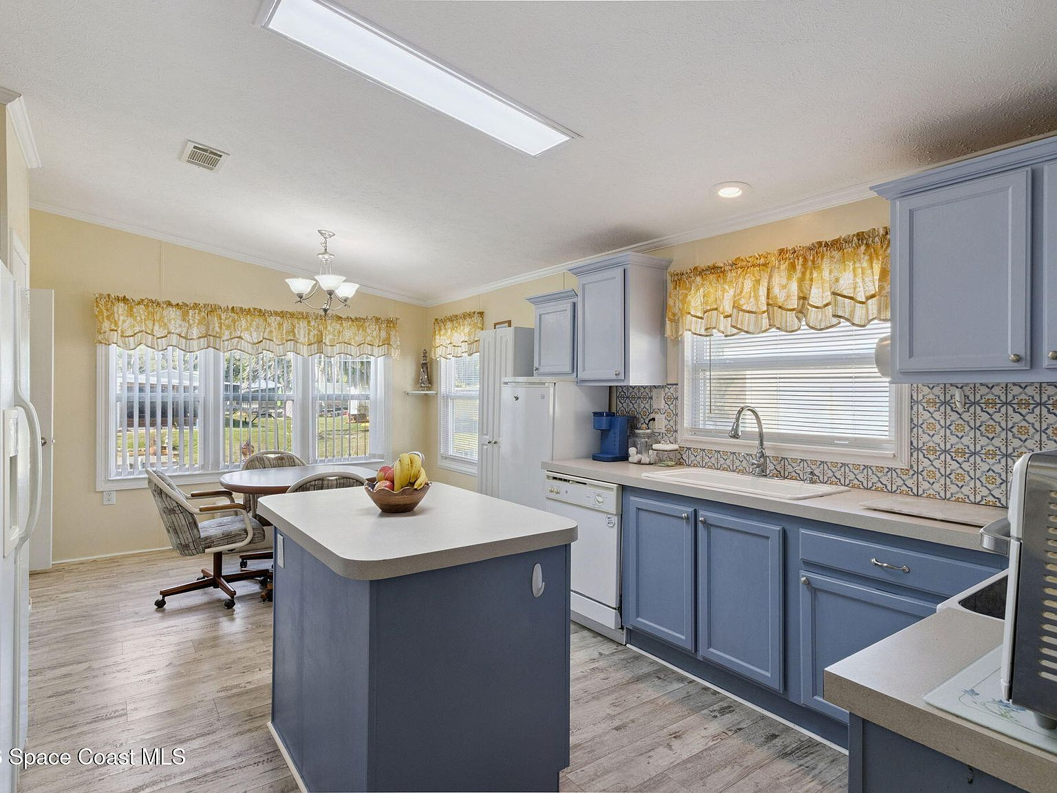 Open-concept kitchen and dining area with blue cabinets