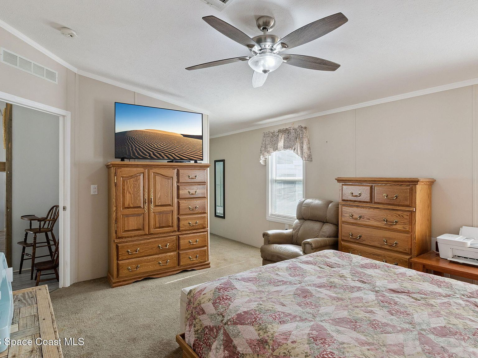 Master bedroom with wooden armoire and carpet flooring