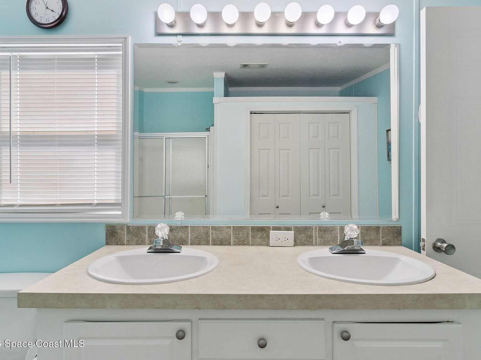 Bathroom with double sink vanity and bright vanity lighting
