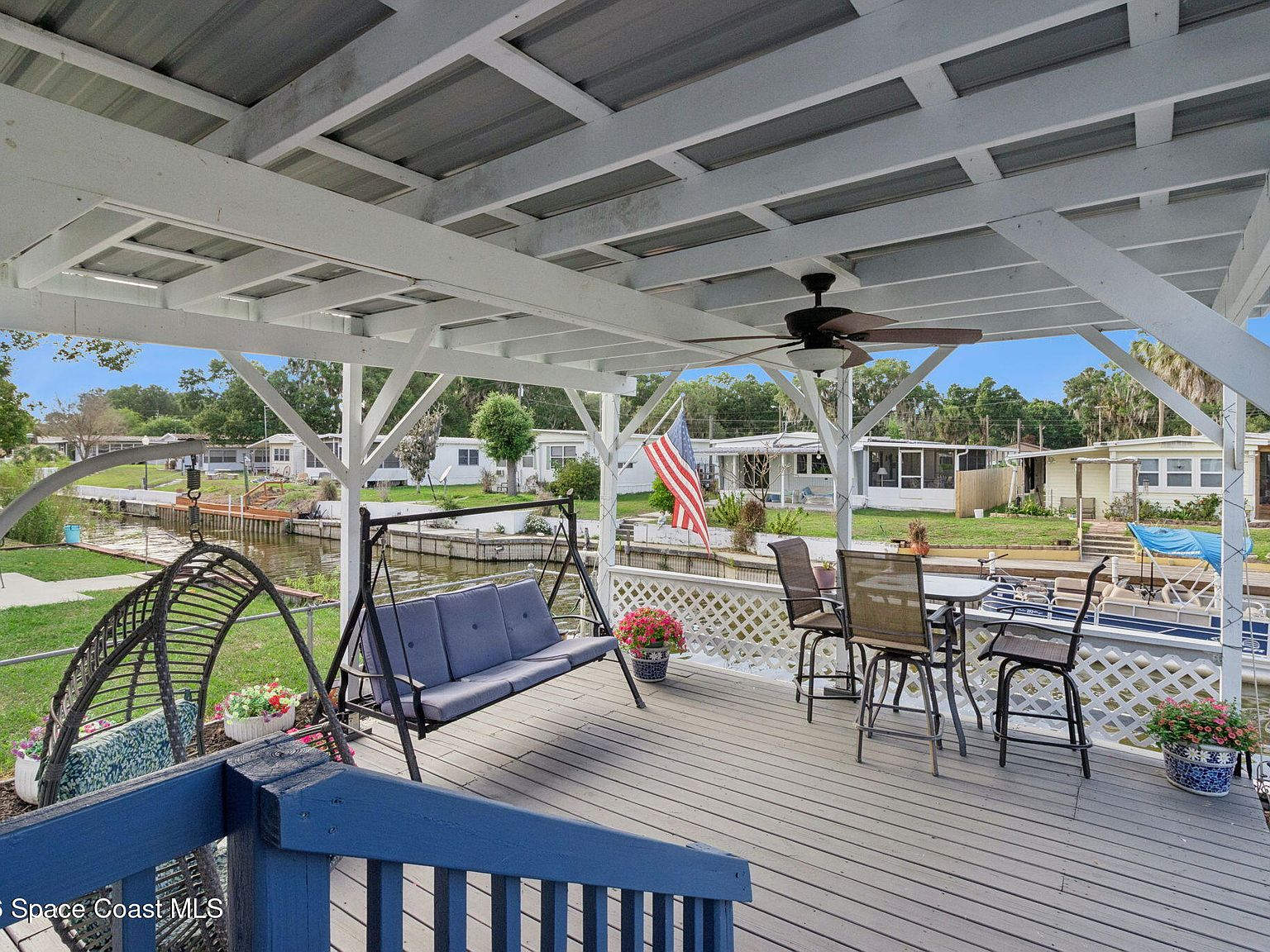 Covered back deck overlooking the canal with blue sky beyond
