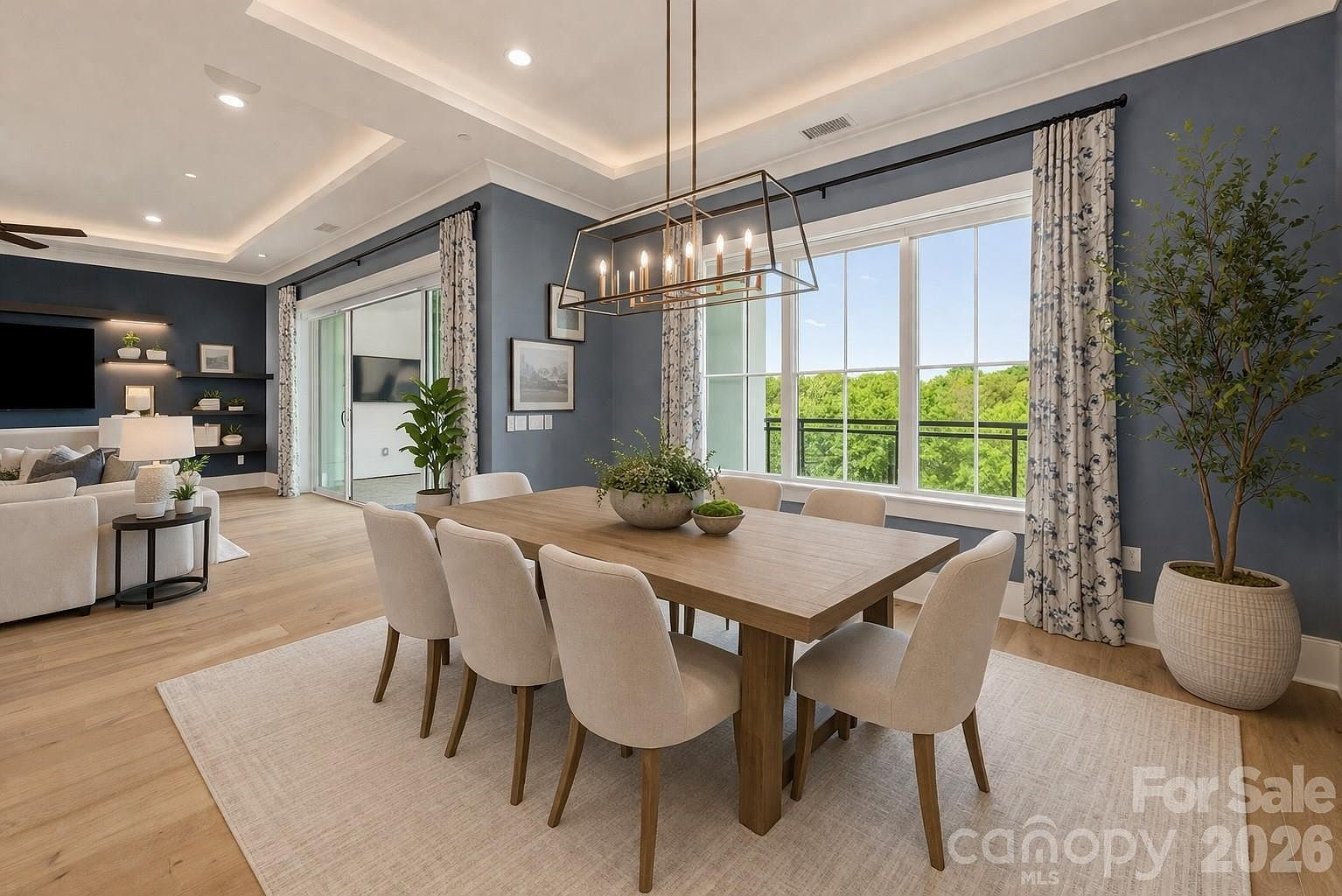 Dining room with tray ceiling, multi-pane windows, and balcony access