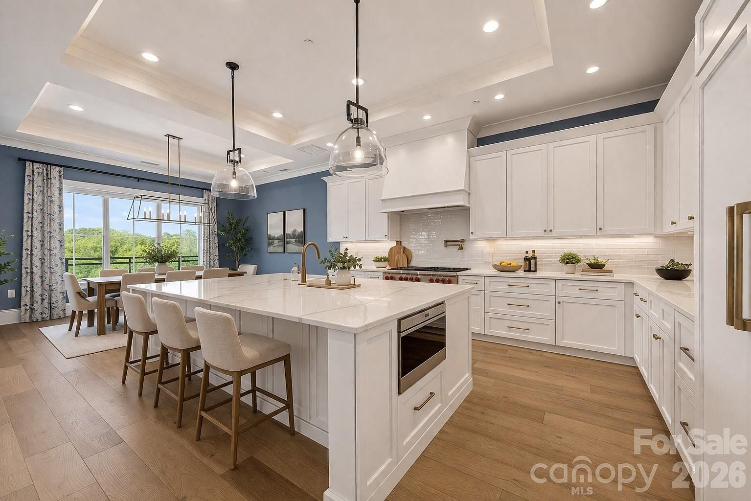 Modern kitchen with white shaker cabinets, quartz island, and navy blue accent wall