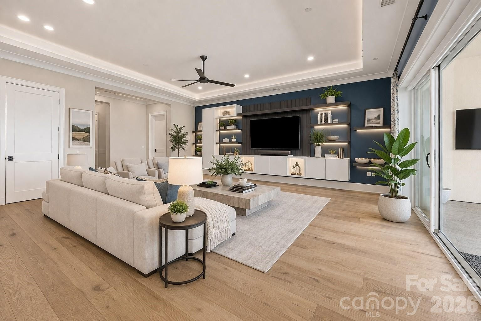 Living room with navy feature wall, custom shelving, and sliding glass patio doors