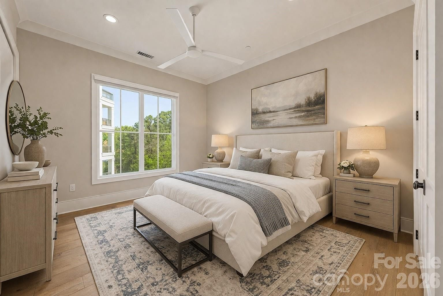 Master bedroom with neutral tones, light oak floors, and white trim
