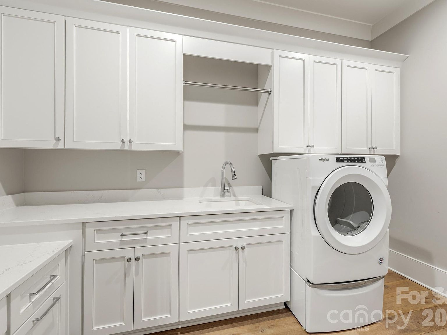Laundry room with white shaker cabinetry, quartz countertops, and under-mount sink