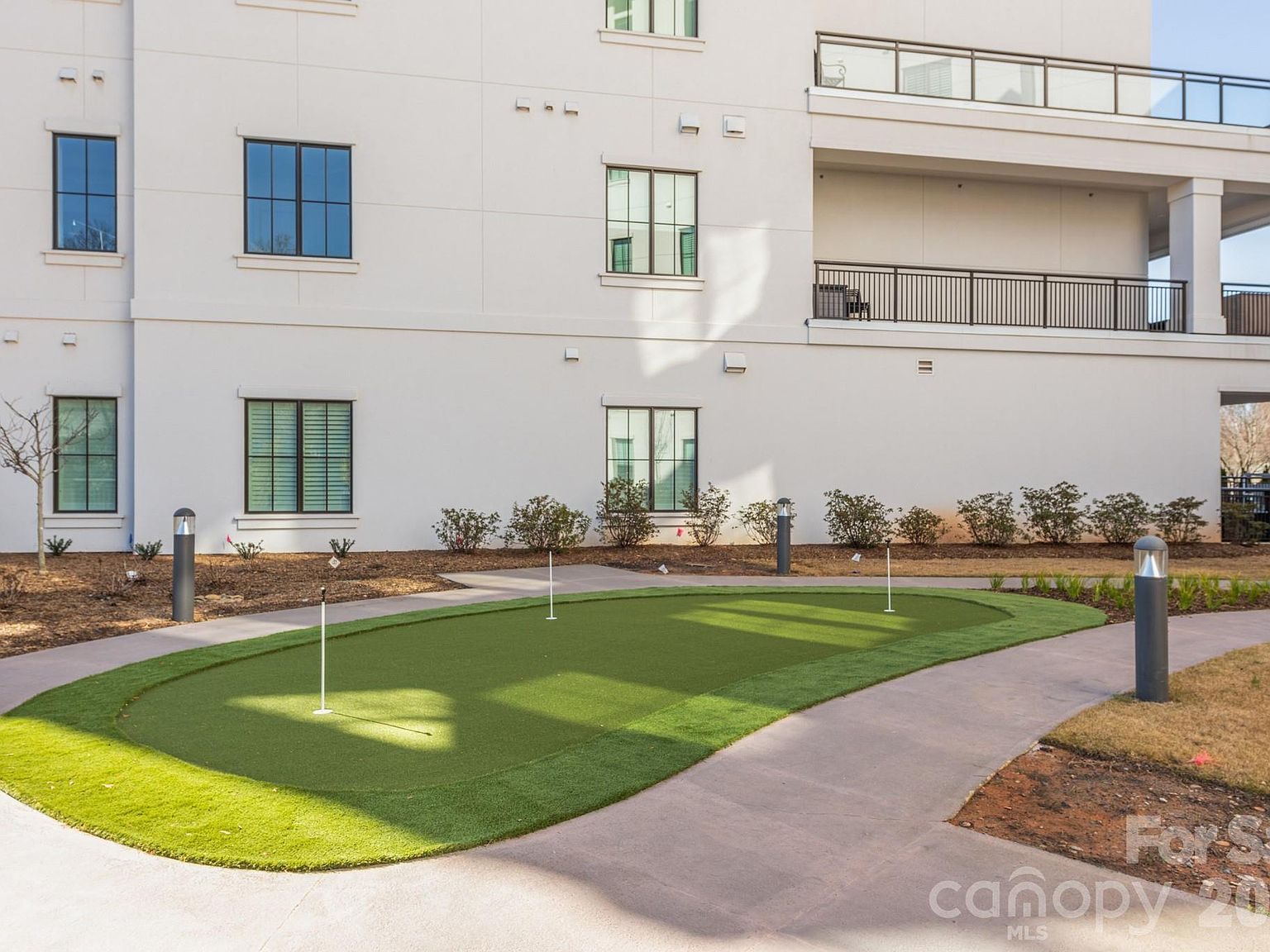 Community putting green with synthetic turf and three pins