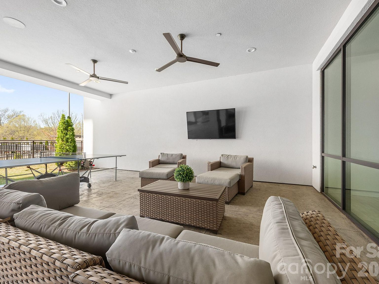 Covered outdoor patio lanai with sliding glass doors and textured flooring