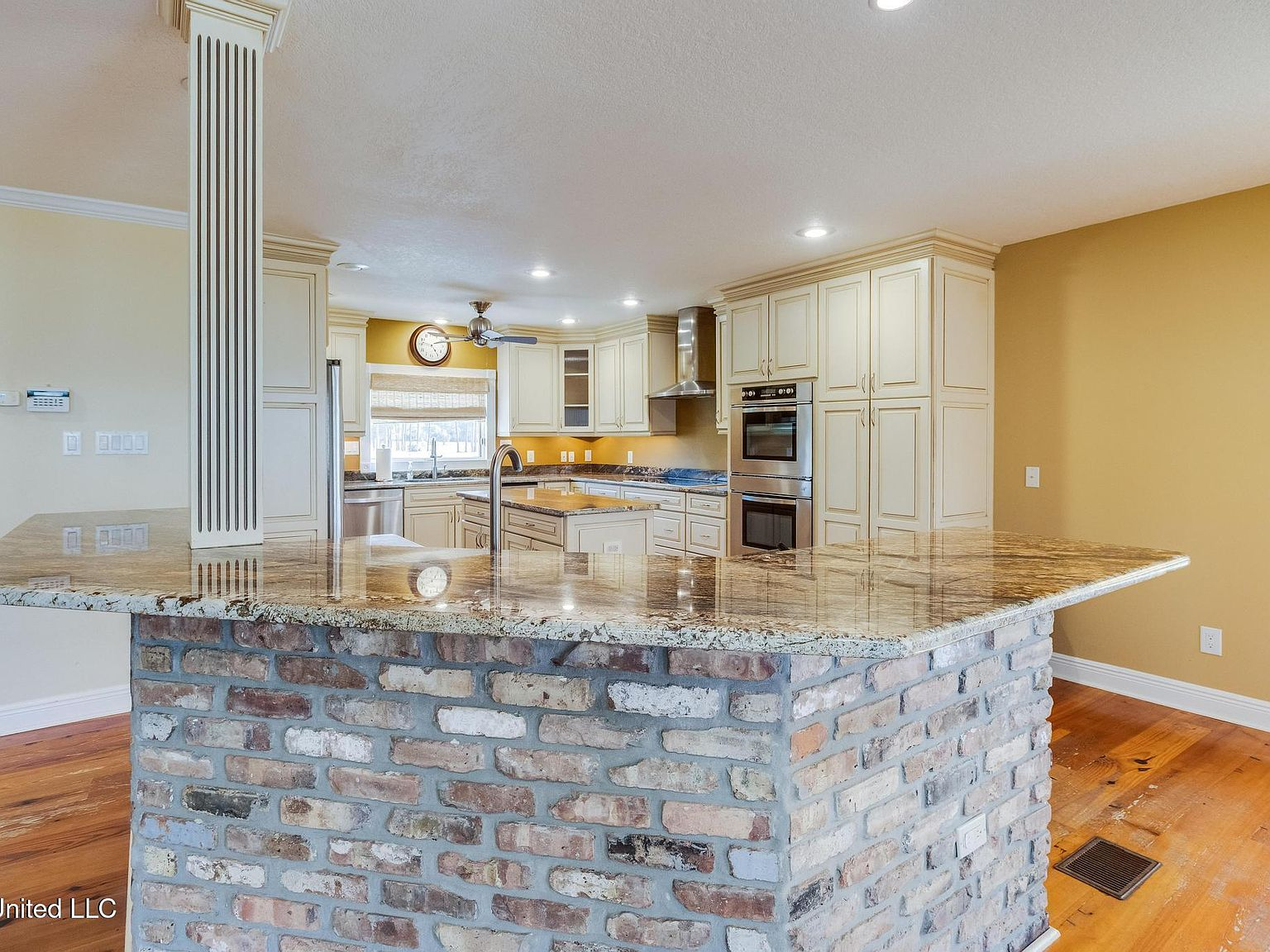 Kitchen breakfast bar with brick-facing and granite countertops