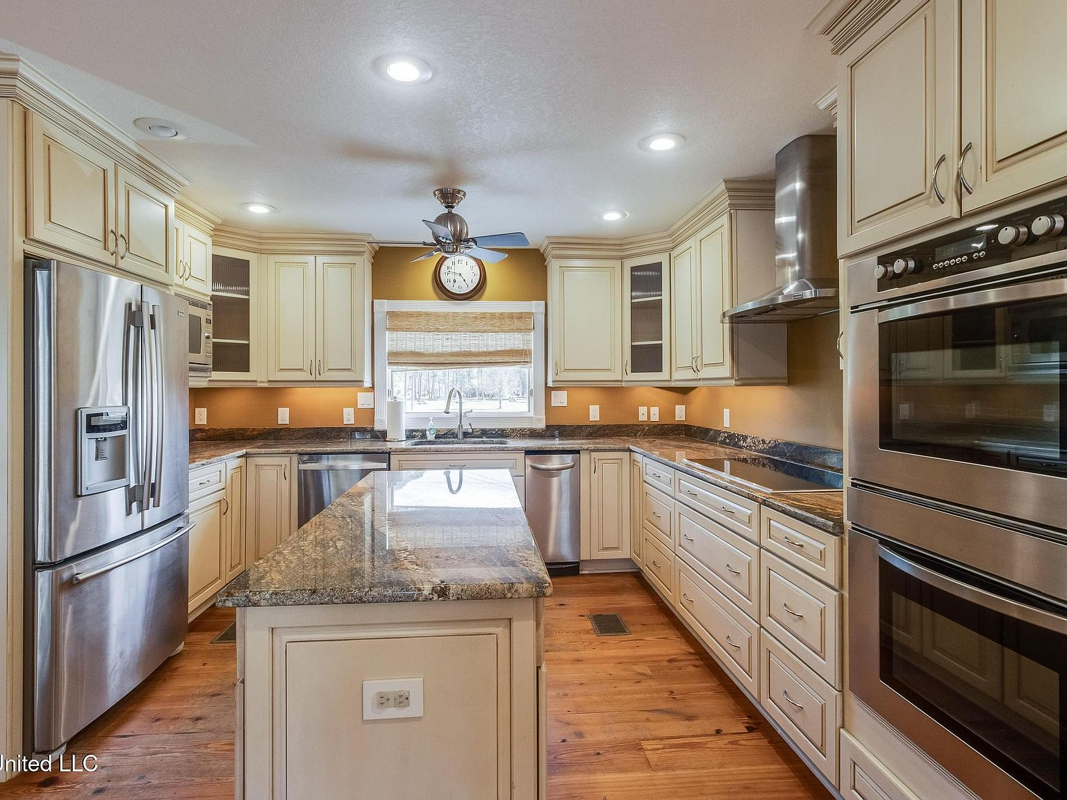 Kitchen with white cabinetry, granite countertops, and stainless steel appliances