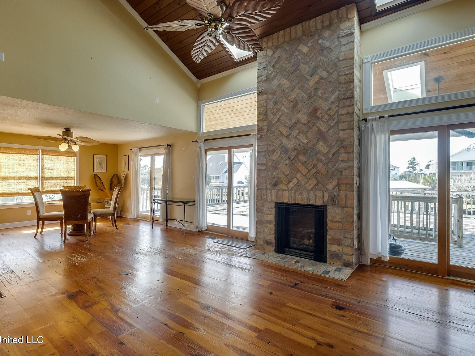 Great room with vaulted wood ceiling and floor-to-ceiling brick fireplace