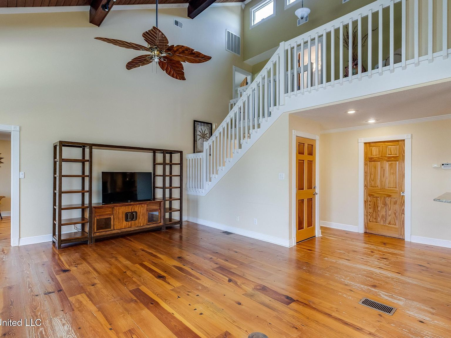 Great room with staircase leading to upper loft landing and transom windows